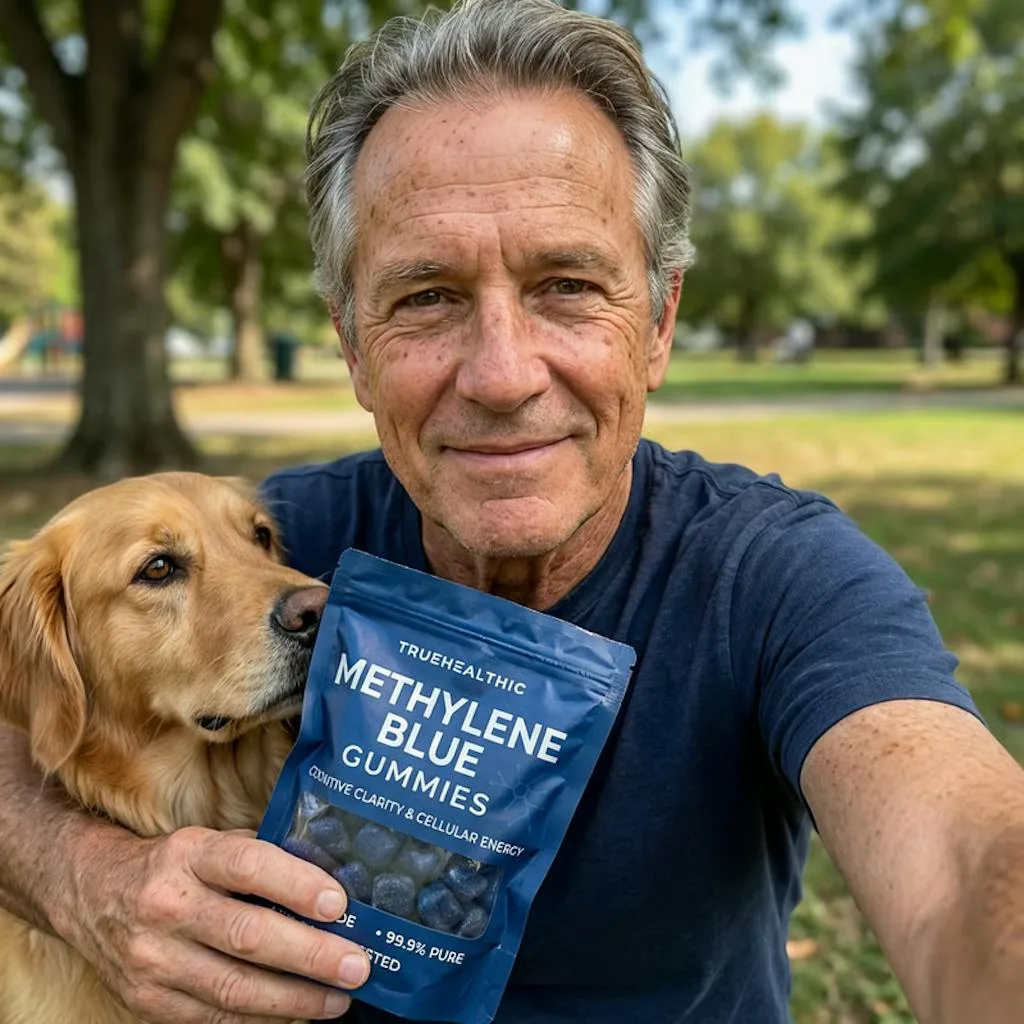 A man holds his golden retriever and a pouch of Methylene Blue Gummies while taking a selfie outdoors.