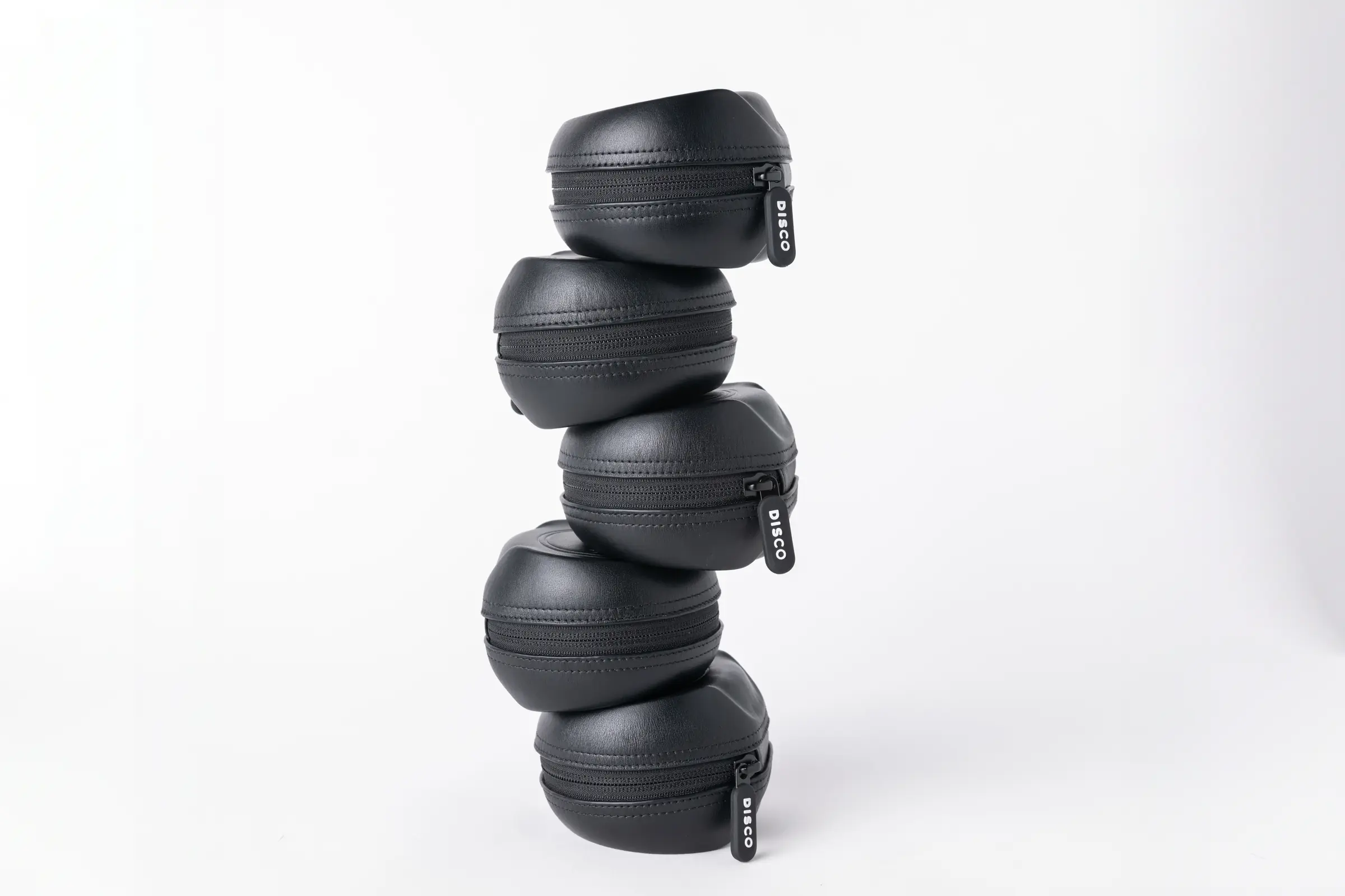 Five black Pucks stacked on top of each other against a white backdrop