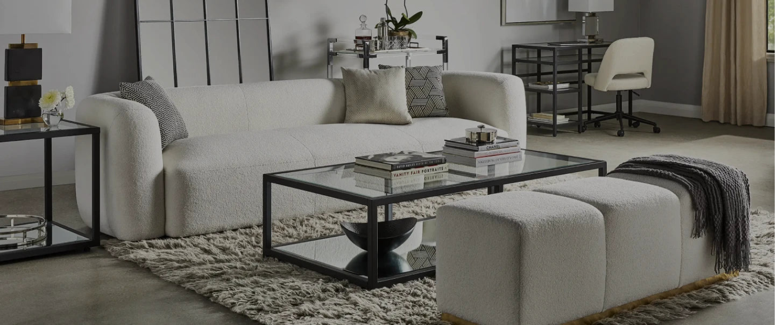 Modern living room with white sofa, glass coffee table, and decorative pillows.