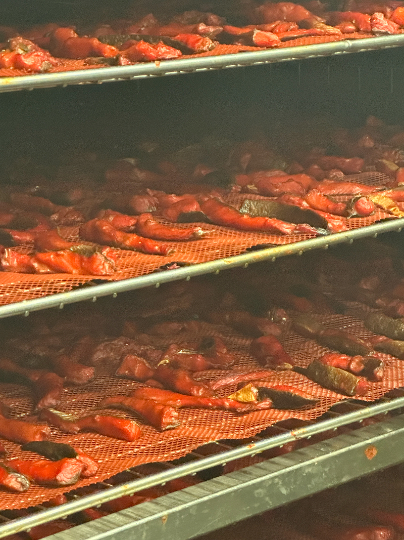 Racks of drying red peppers on mesh trays.