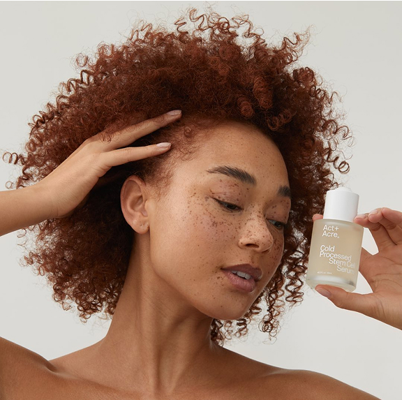 Person holding a bottle of Act+Acre Cold Processed Stem Cell Serum.