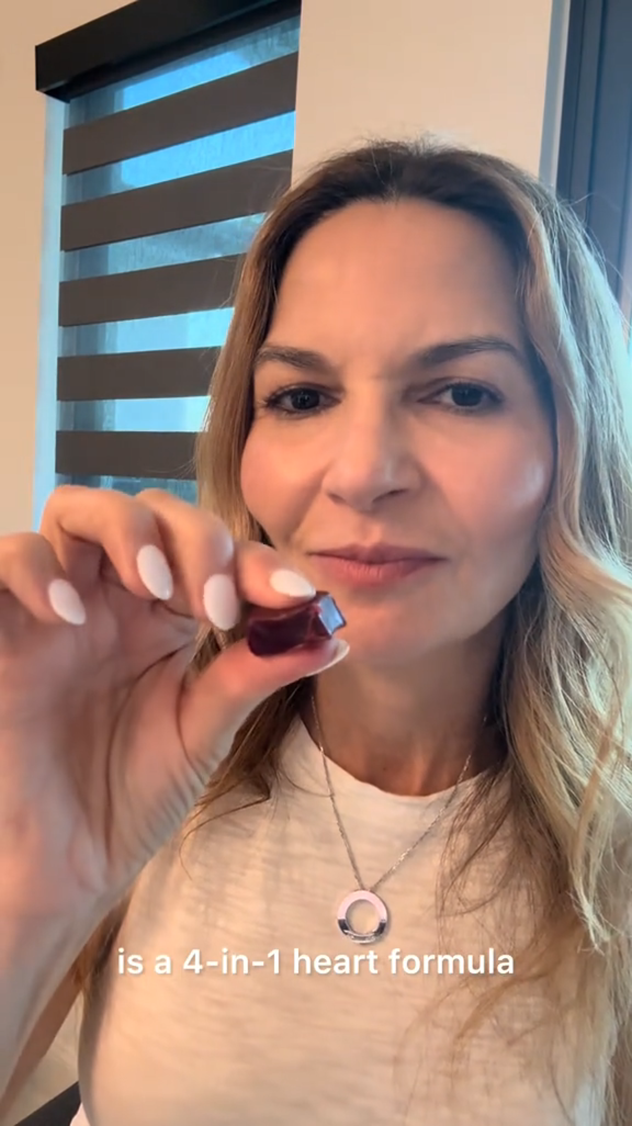 Person holding a supplement, text mentions '4-in-1 heart formula.'