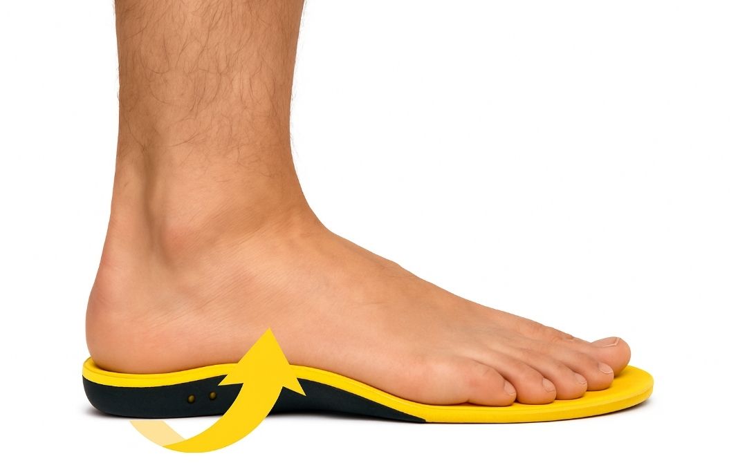 A side view of a person's foot on a yellow and black insole showing arch support.