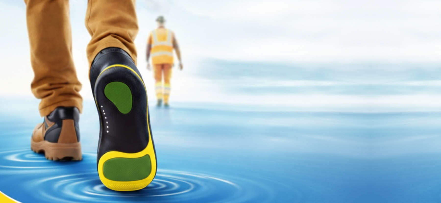 A close-up of a work boot's sole as a person walks on rippling blue water.