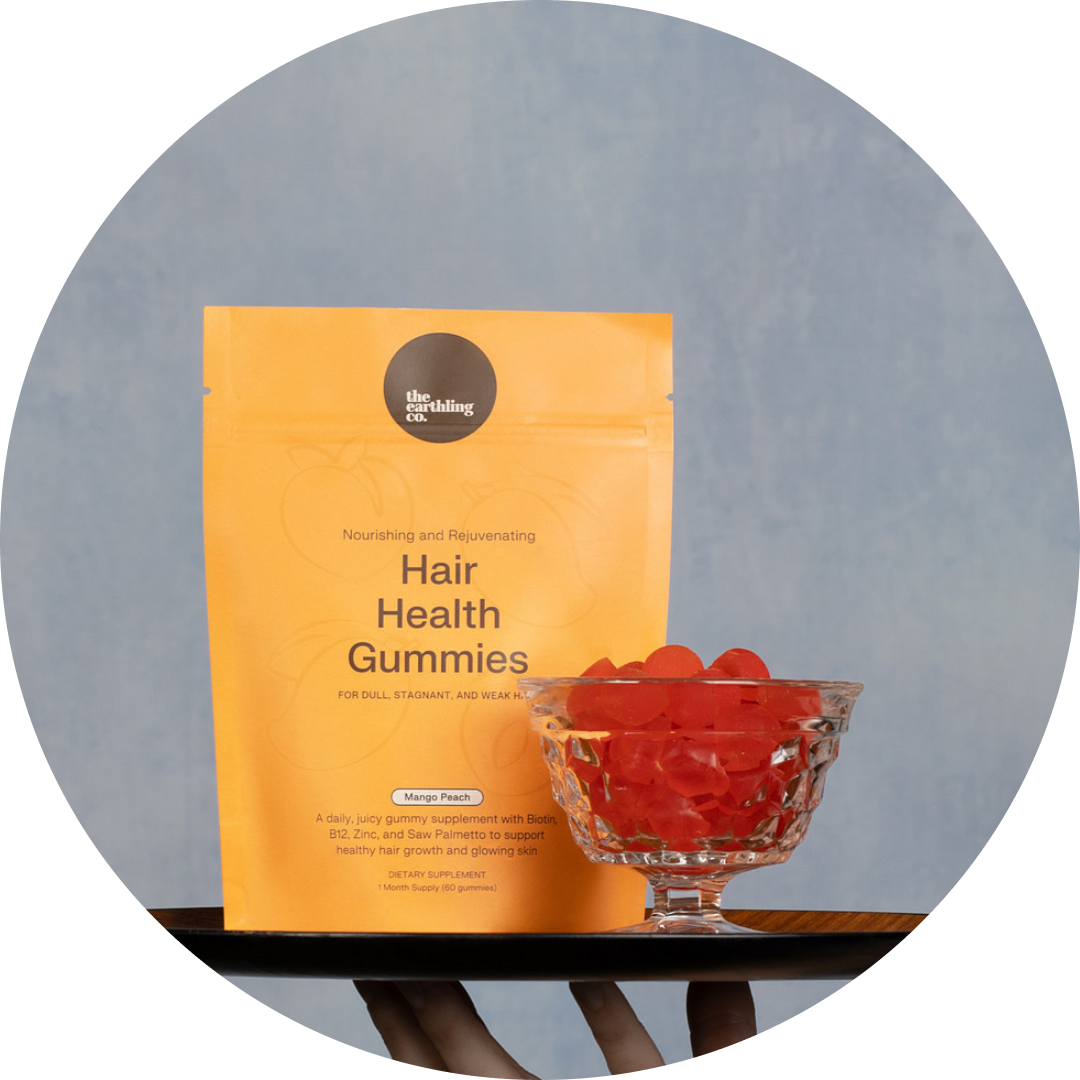 Orange bag of Hair Health Gummies with a glass bowl of red gummies in front.