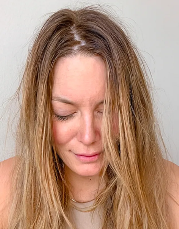 Woman with long, straight hair looking down with eyes closed.