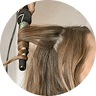 Person curling their hair with a curling iron.