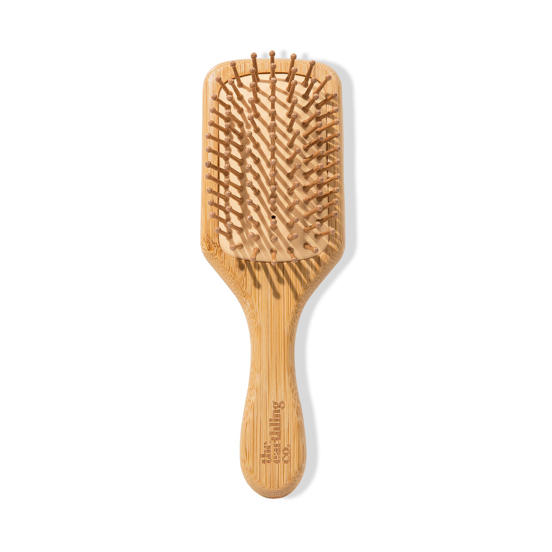 Wooden paddle hairbrush with bristles on a white background.