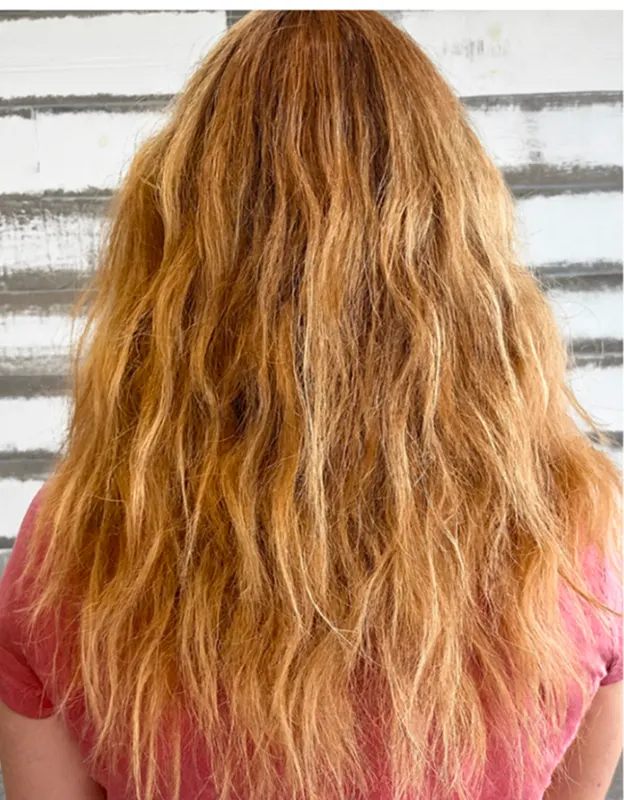 Person with long, wavy red hair, facing away.