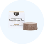 A round, brown conditioner bar sitting next to its white and tan packaging box.