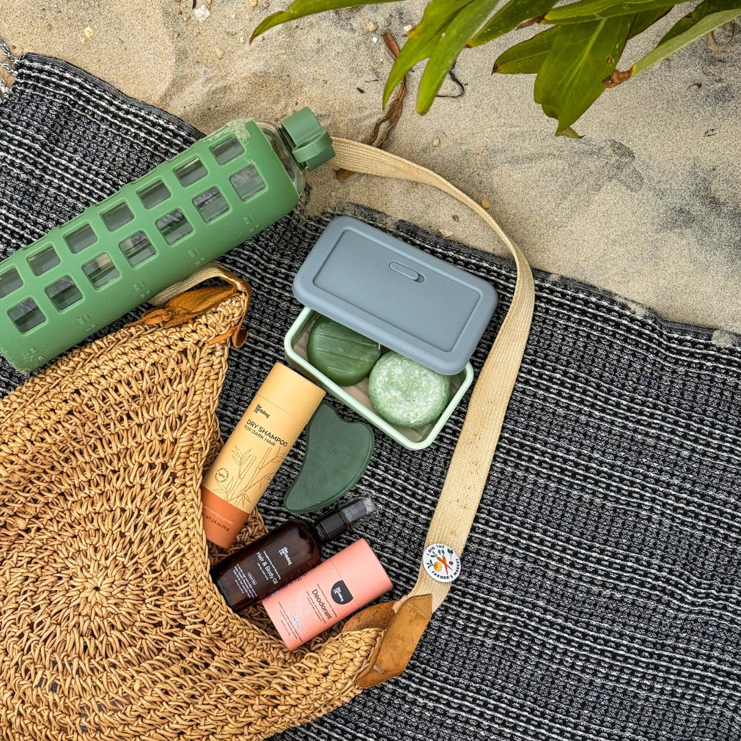 shampoo & conditioner bars with a travel case and other travel sized products on the beach