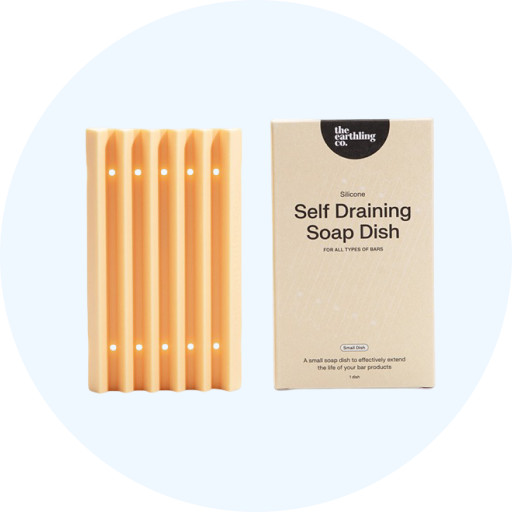 A peach-colored, silicone self-draining soap dish next to its cardboard packaging from The Earthling Co.