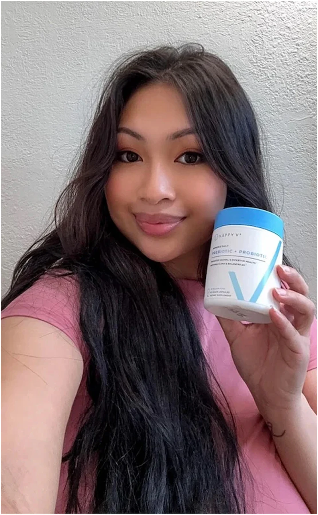 Person holding a container labeled 'Probiotic + Prebiotic' with a blue lid.