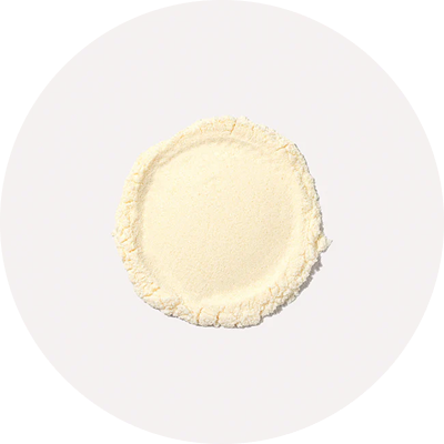A circular mound of fine, light-colored powder on a white background.