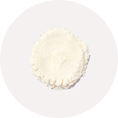 A circular mound of white powder on a light background.