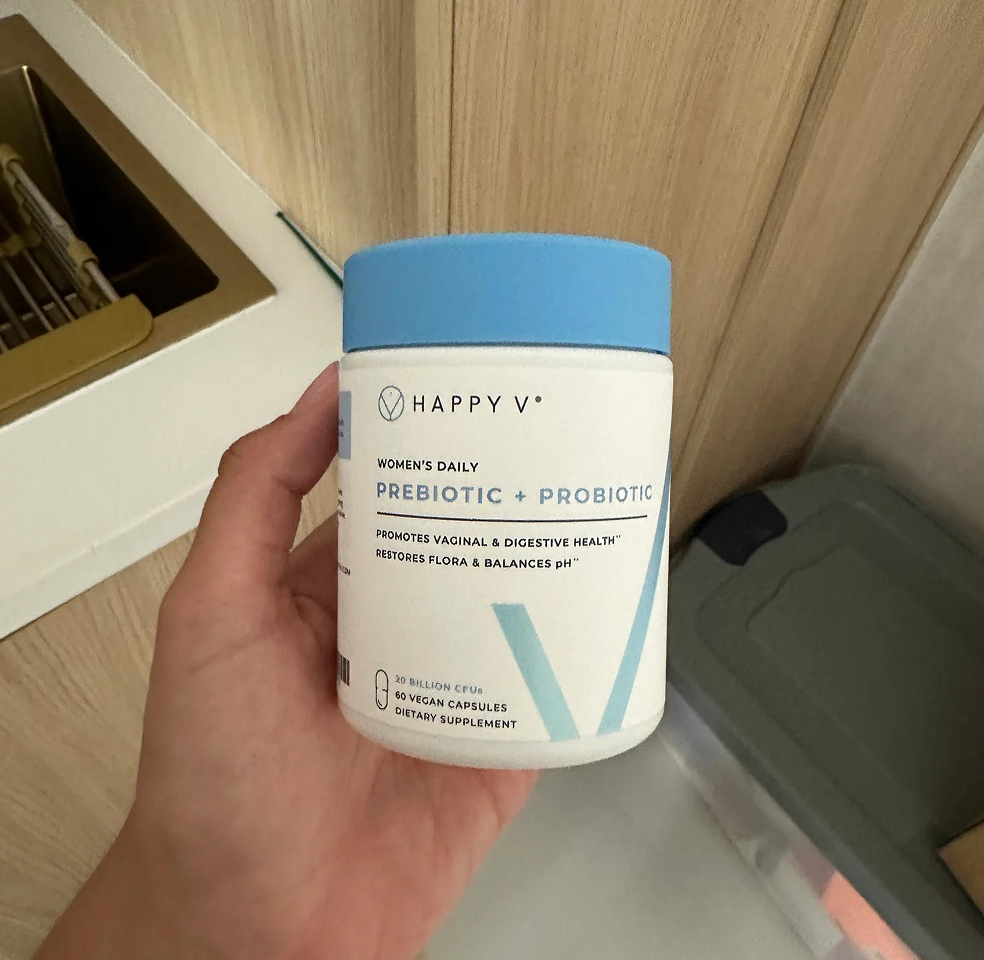 Hand holding a container of women's daily prebiotic and probiotic supplement.