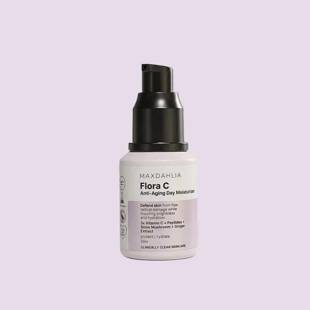A pump bottle of Maxdahlia Flora C Anti-Aging Day Moisturizer against a solid lavender background.