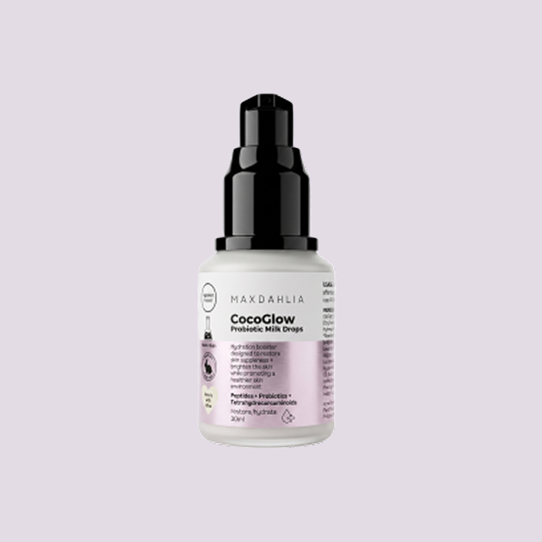 A bottle of Maxdahlia CocoGlow Probiotic Milk Drops with a black pump against a lilac background.