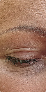 A close-up of a person's closed eye, showing the eyelid, eyelashes, and eyebrow.