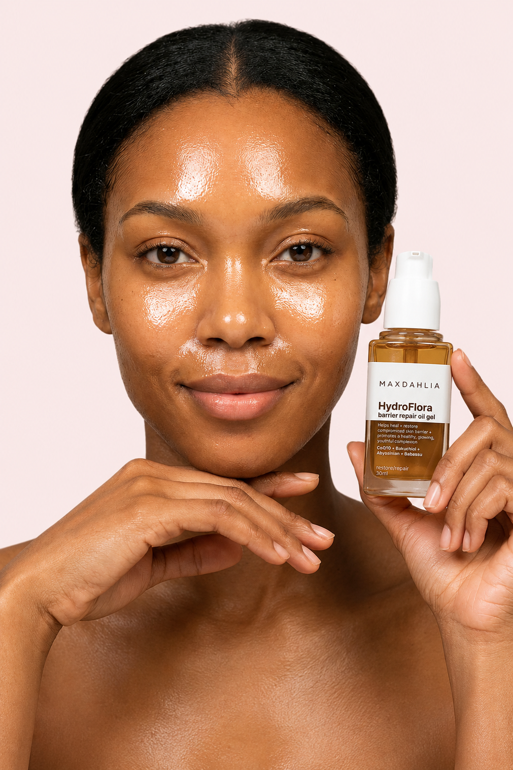 A woman with glowing skin rests her chin on her hand while holding a bottle of Maxdahlia oil gel.