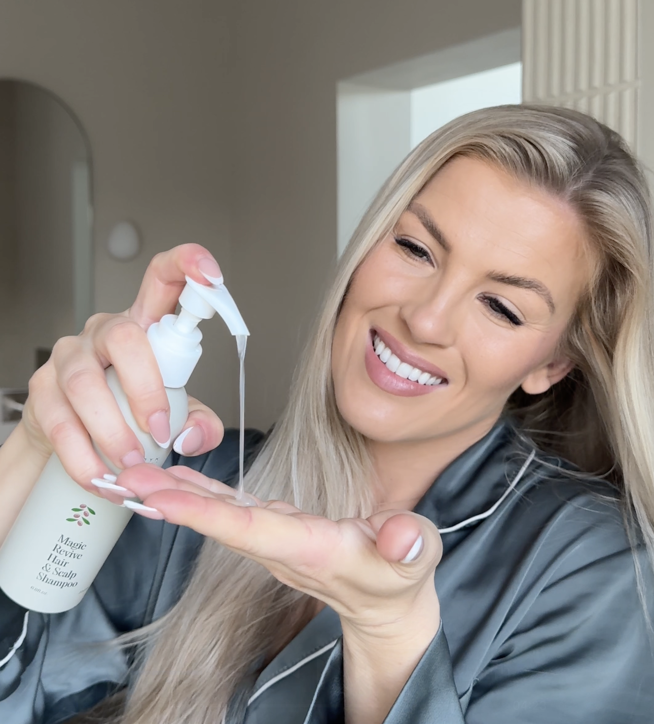 Person smiling while dispensing shampoo into their hand.