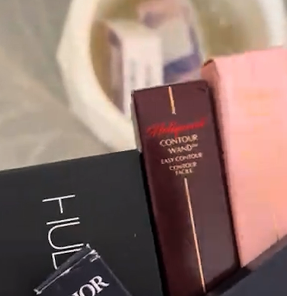 Assorted makeup product boxes, including contour wand and other cosmetics.