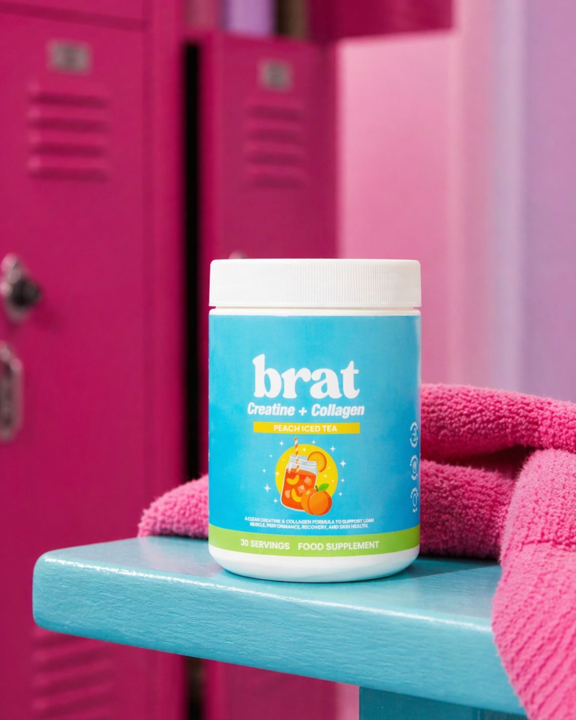 A blue container of Brat Creatine + Collagen sits on a blue bench in front of pink lockers.