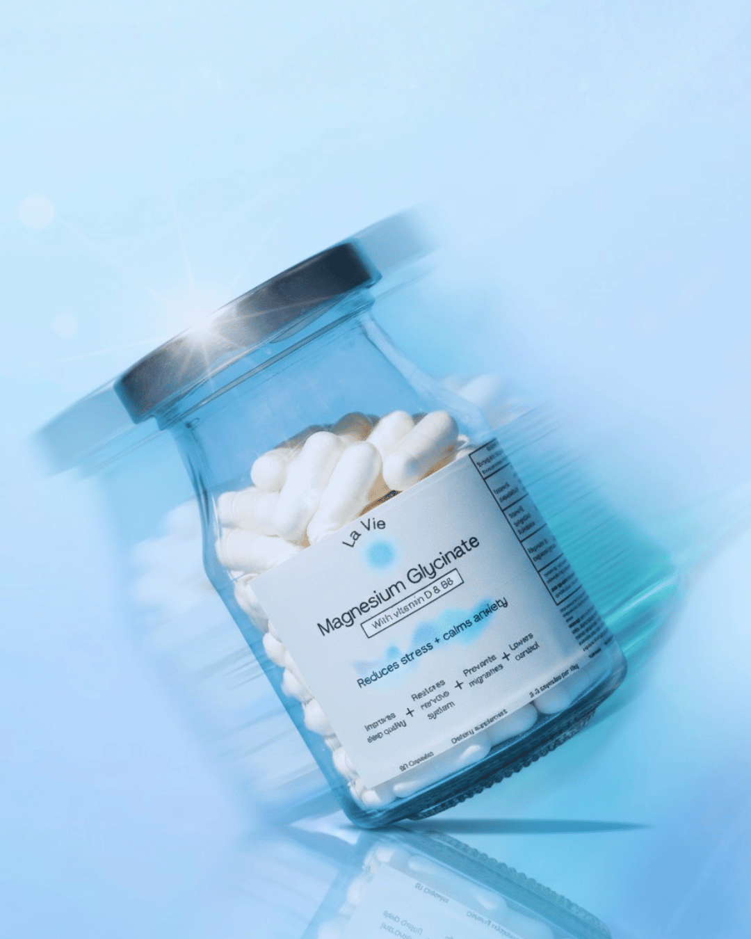 A glass jar of magnesium glycinate capsules on a blue background.