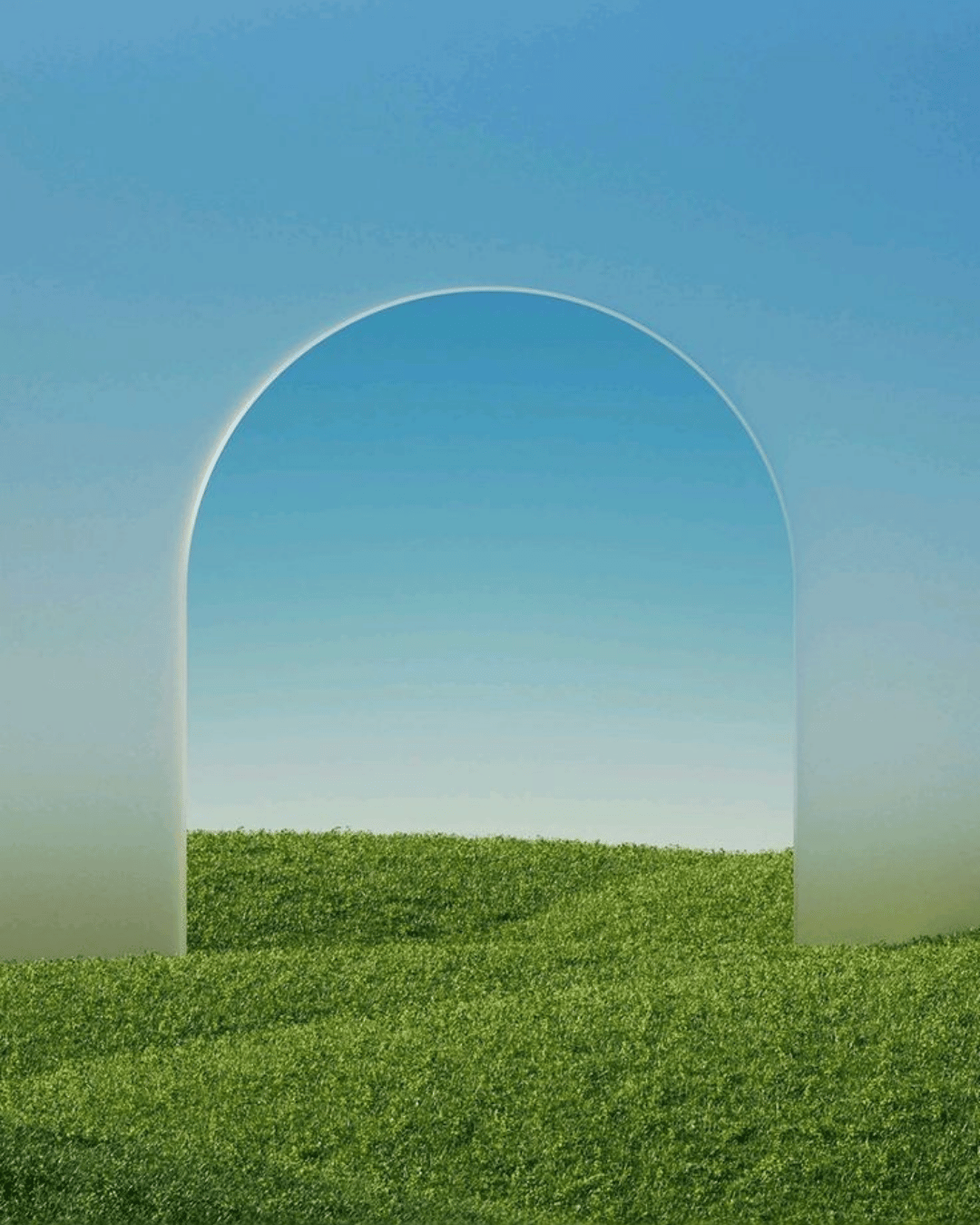 A grassy field with a large archway under a clear blue sky.