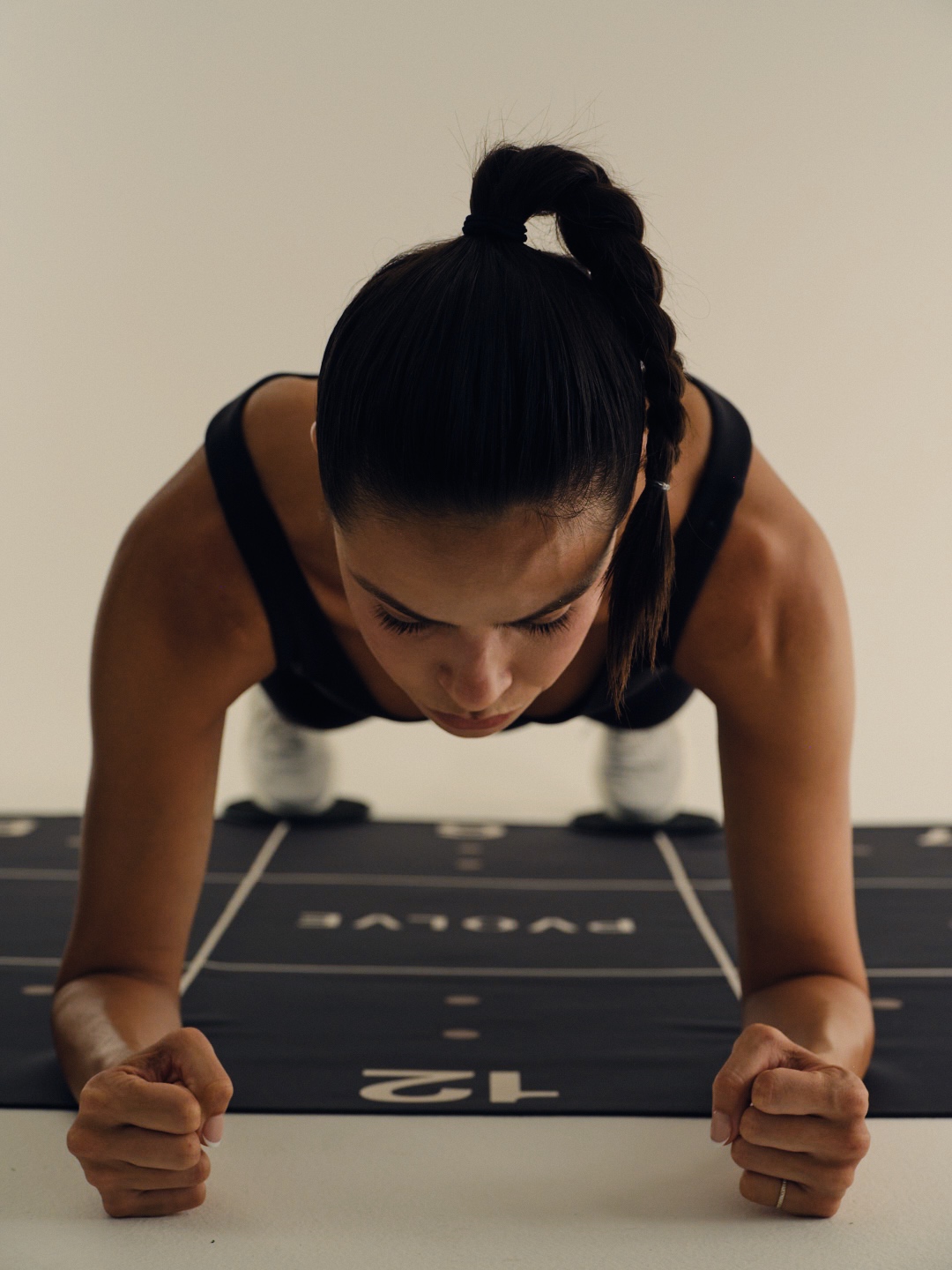 Person doing a plank exercise on a mat indoors.