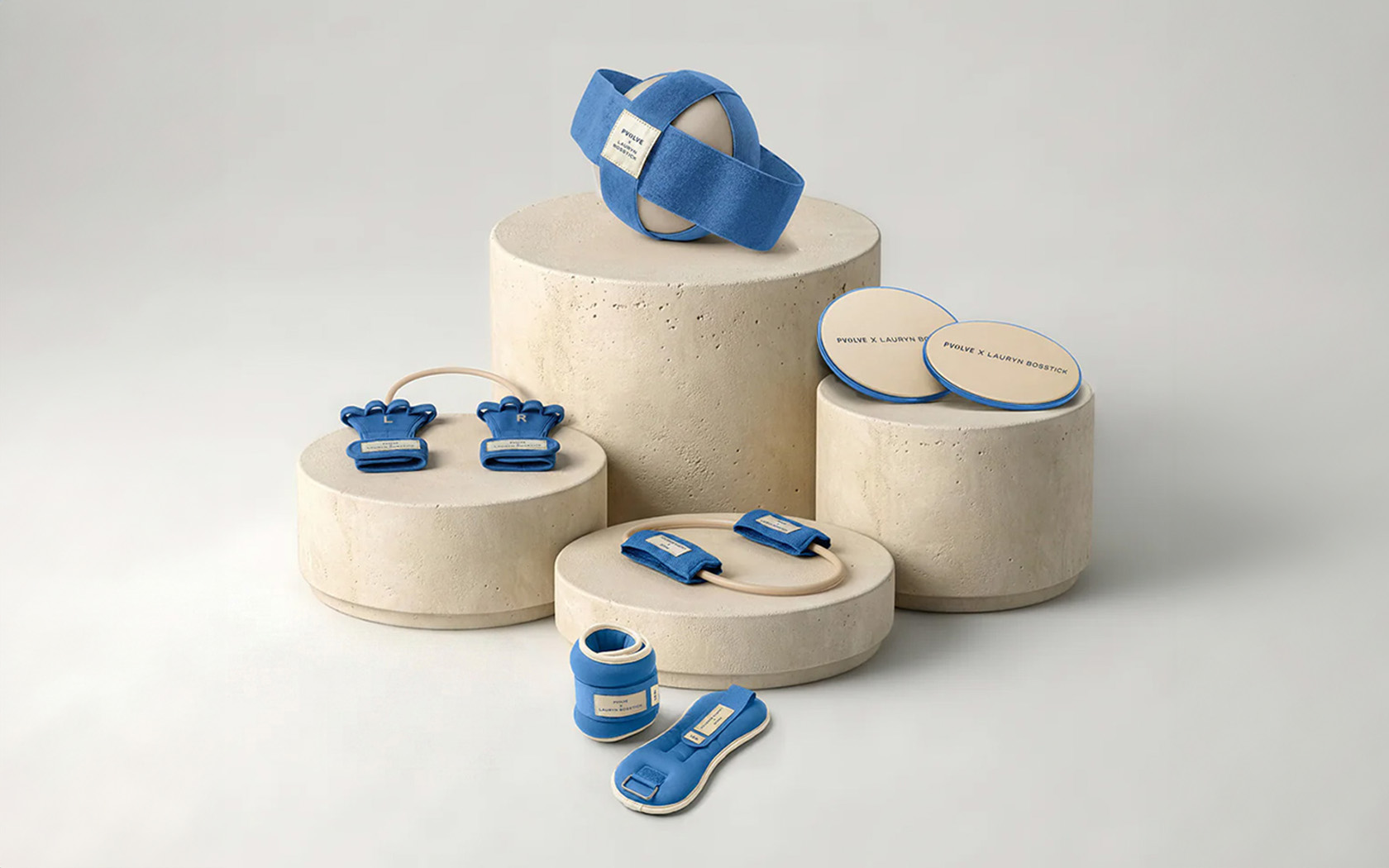 An assortment of blue and cream-colored fitness equipment displayed on stone pedestals against a plain background.