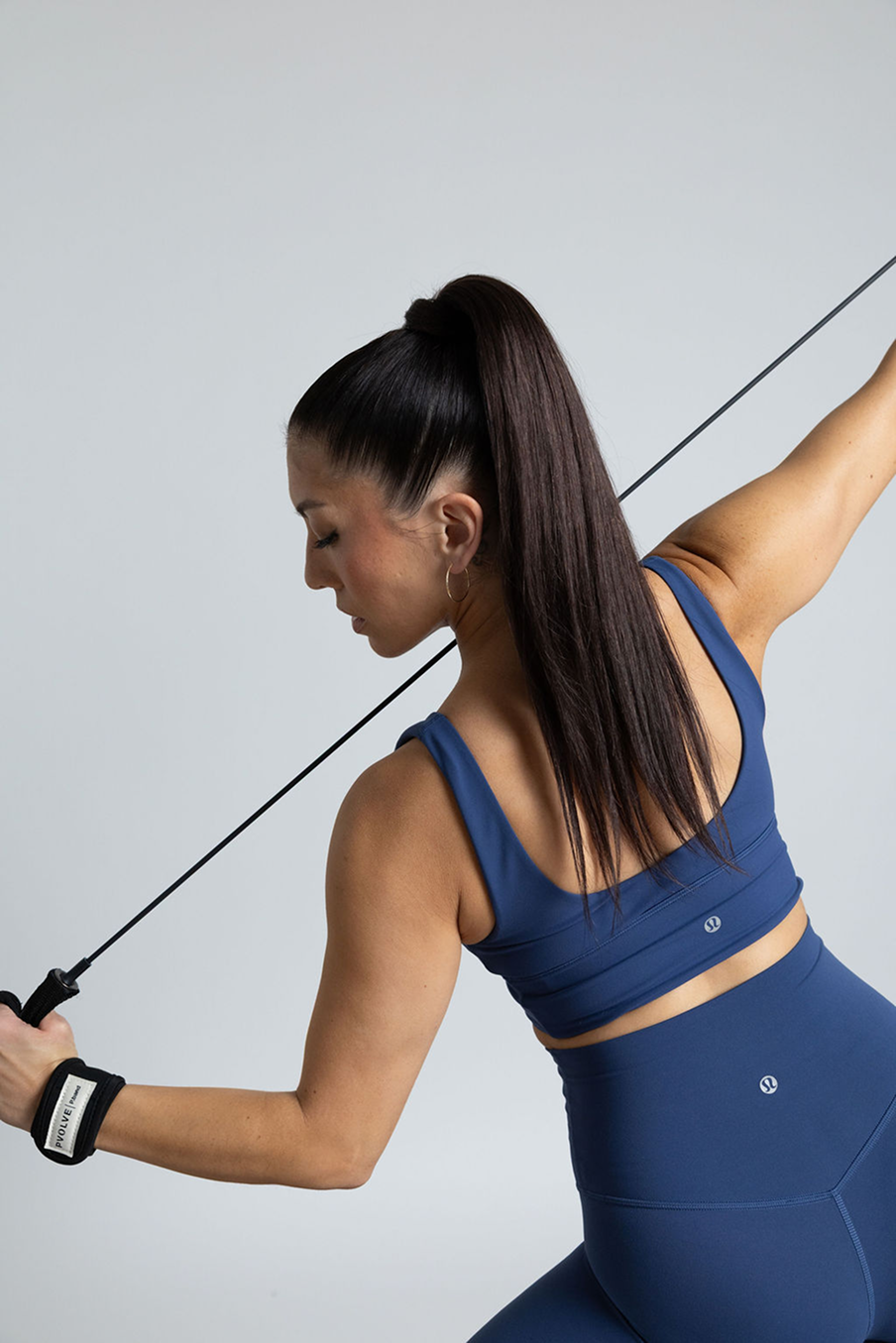 Person working out with resistance band, wearing blue athletic wear.