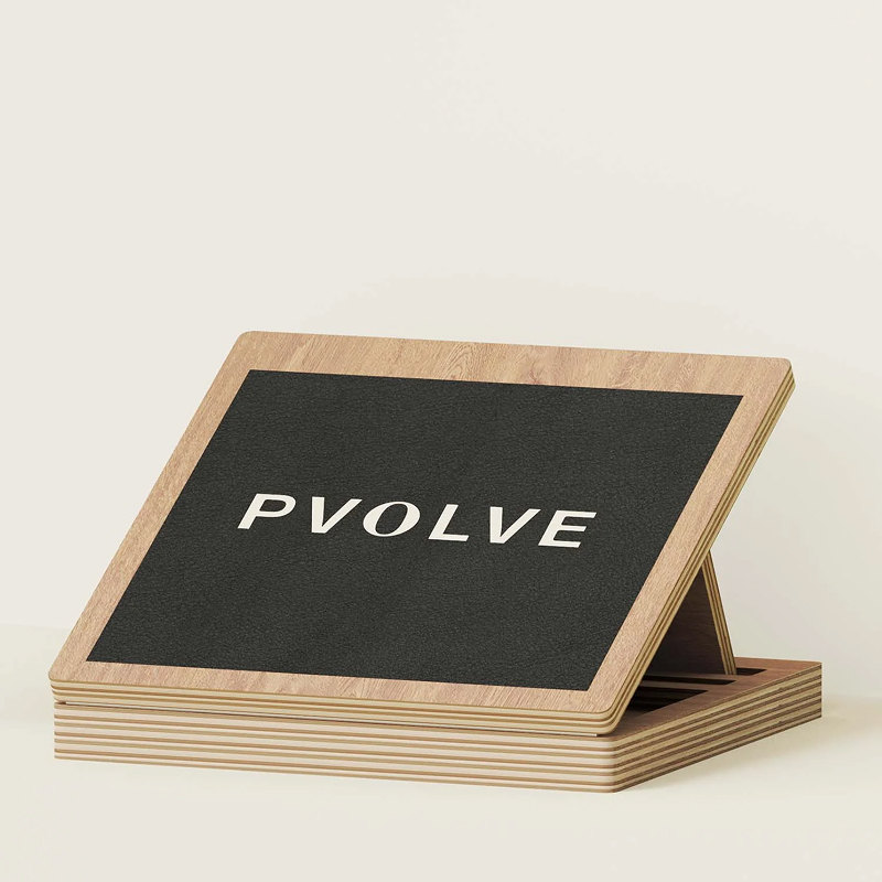 A wooden slant board with a black, textured top that says 'PVOLVE' in white letters.