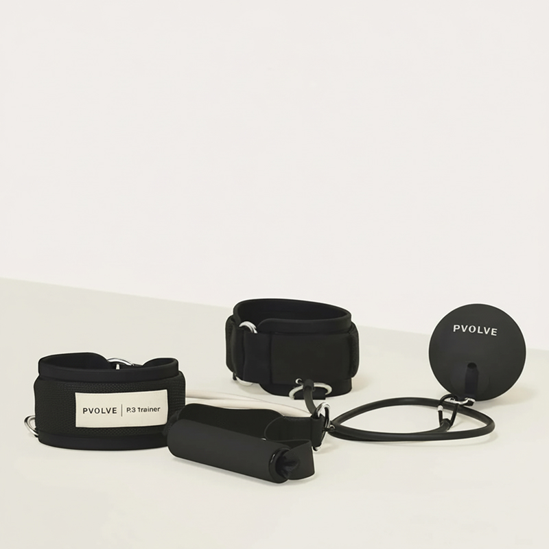 A set of black Pvolve P3 Trainer exercise equipment, including ankle straps and resistance bands.