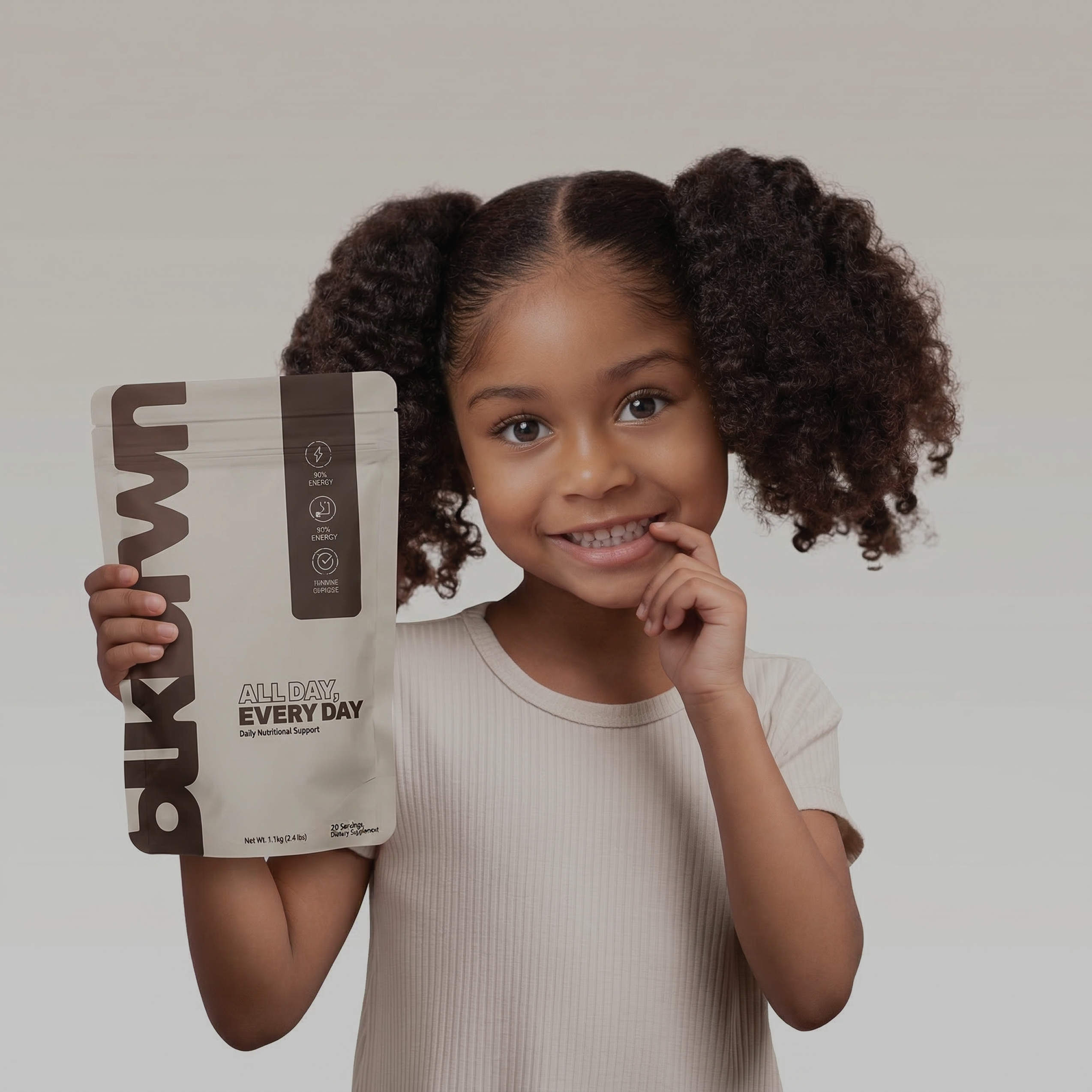 A woman with curly hair holds a pouch of supplements and a green gummy bear.
