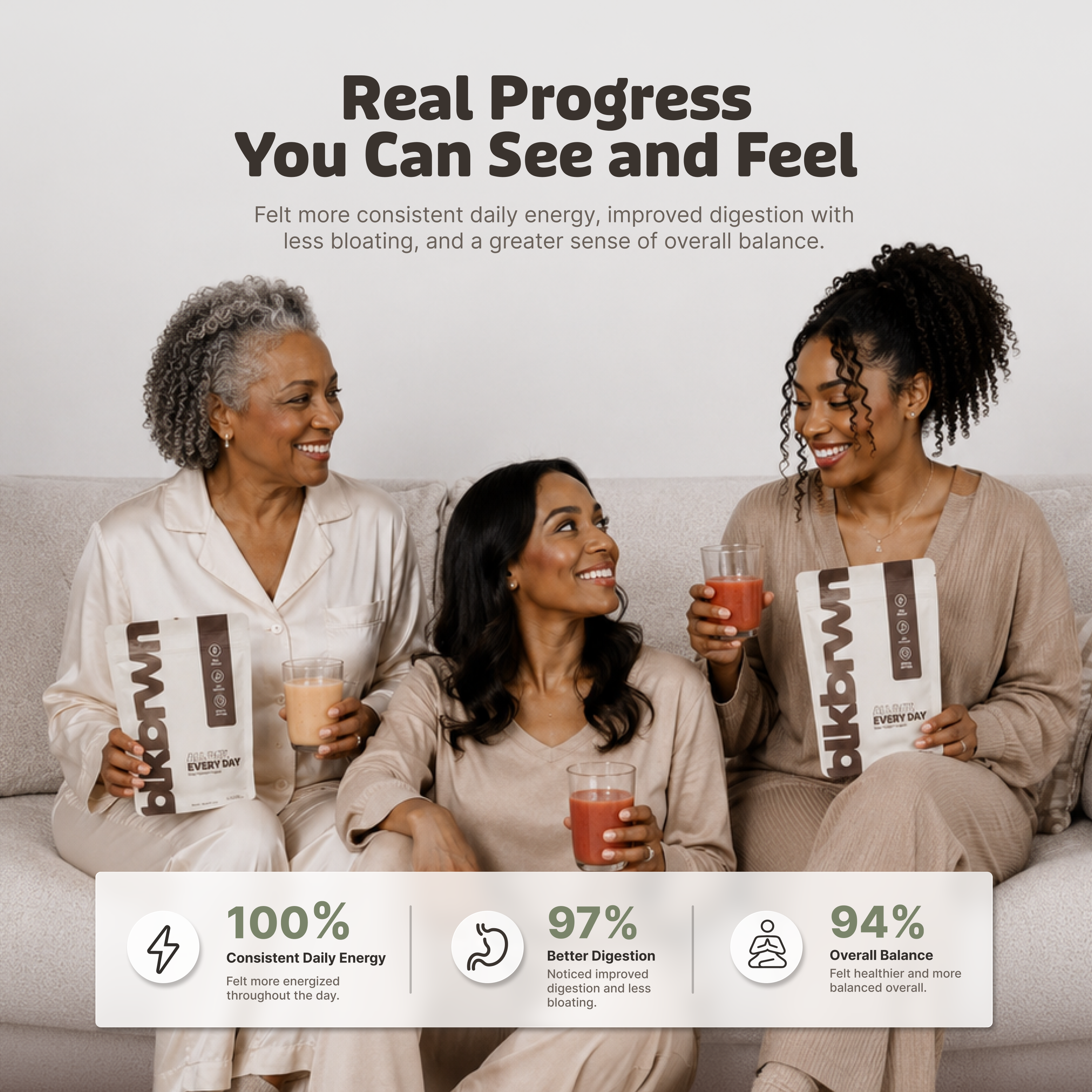 Three women of different ages sit on a couch smiling, holding glasses and pouches of a product.