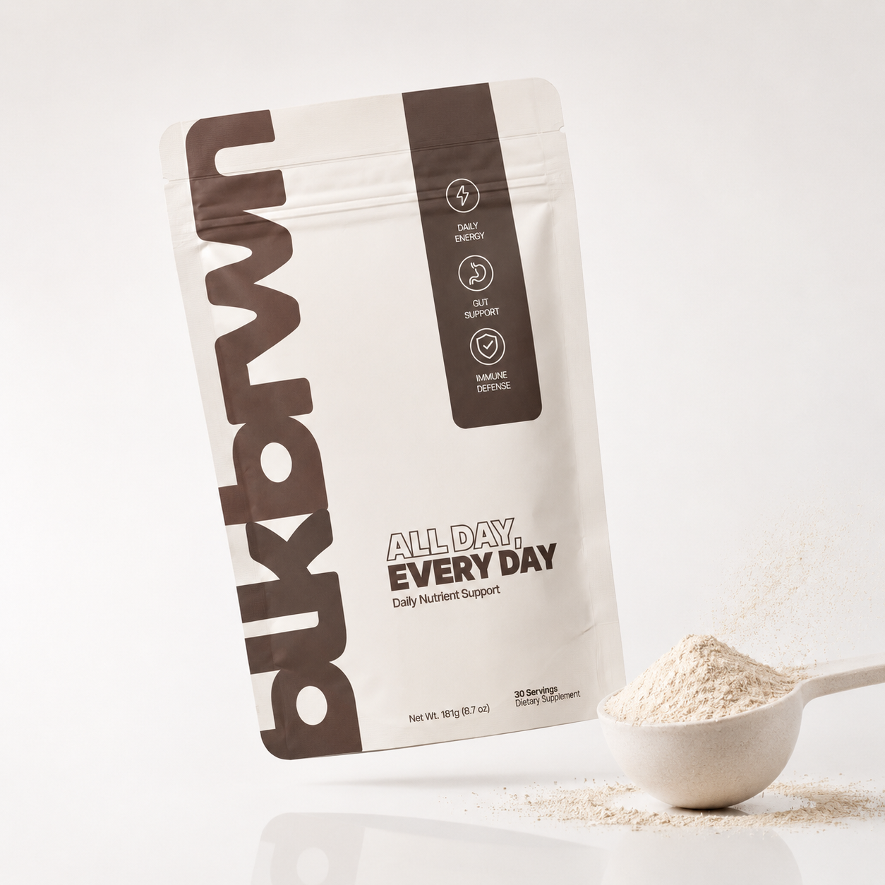 A pouch of Bukbrn Daily Nutrient Support dietary supplement next to a scoop of the powder.