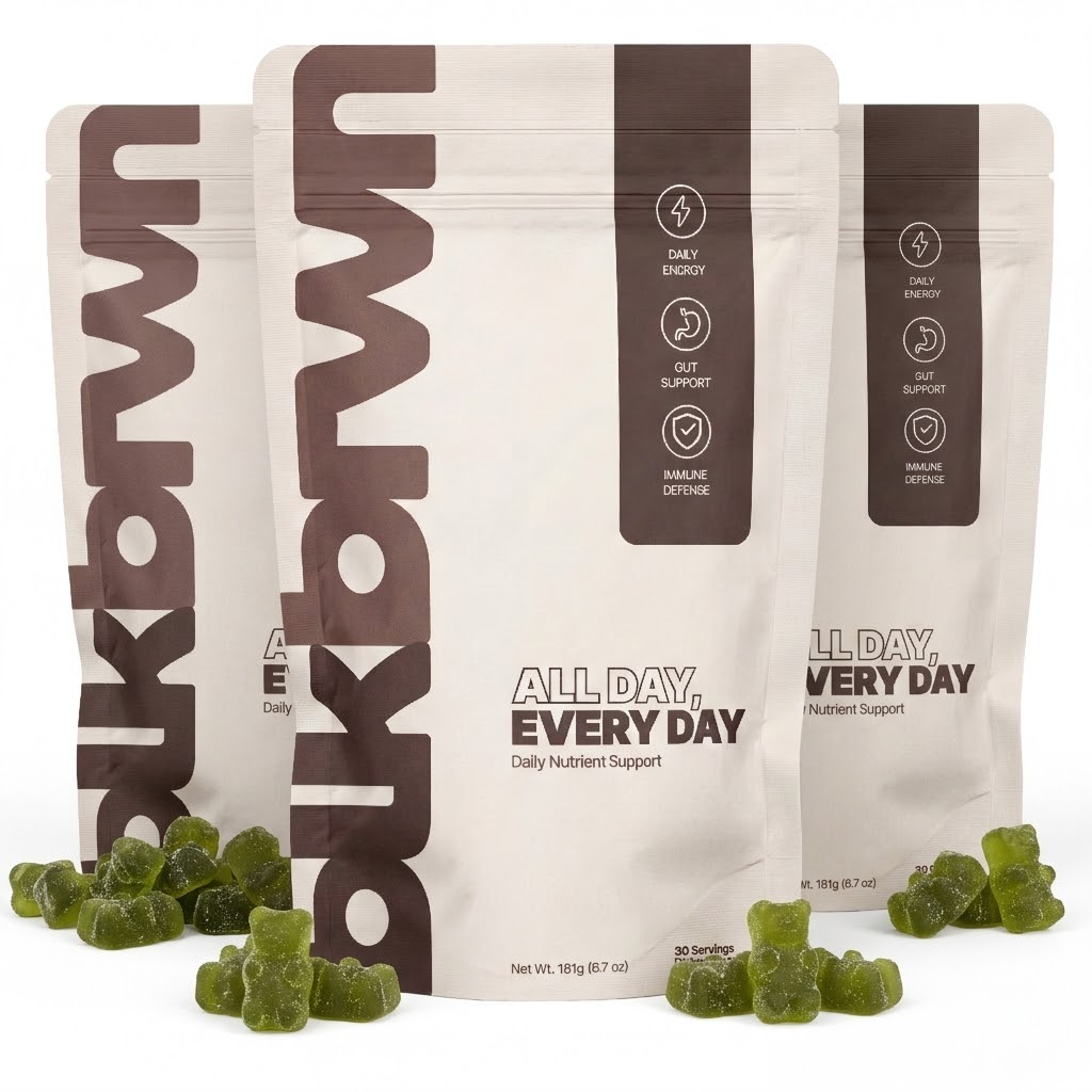 Three pouches of ukbrwn daily supplements with green, bear-shaped gummies scattered in front against a white background.