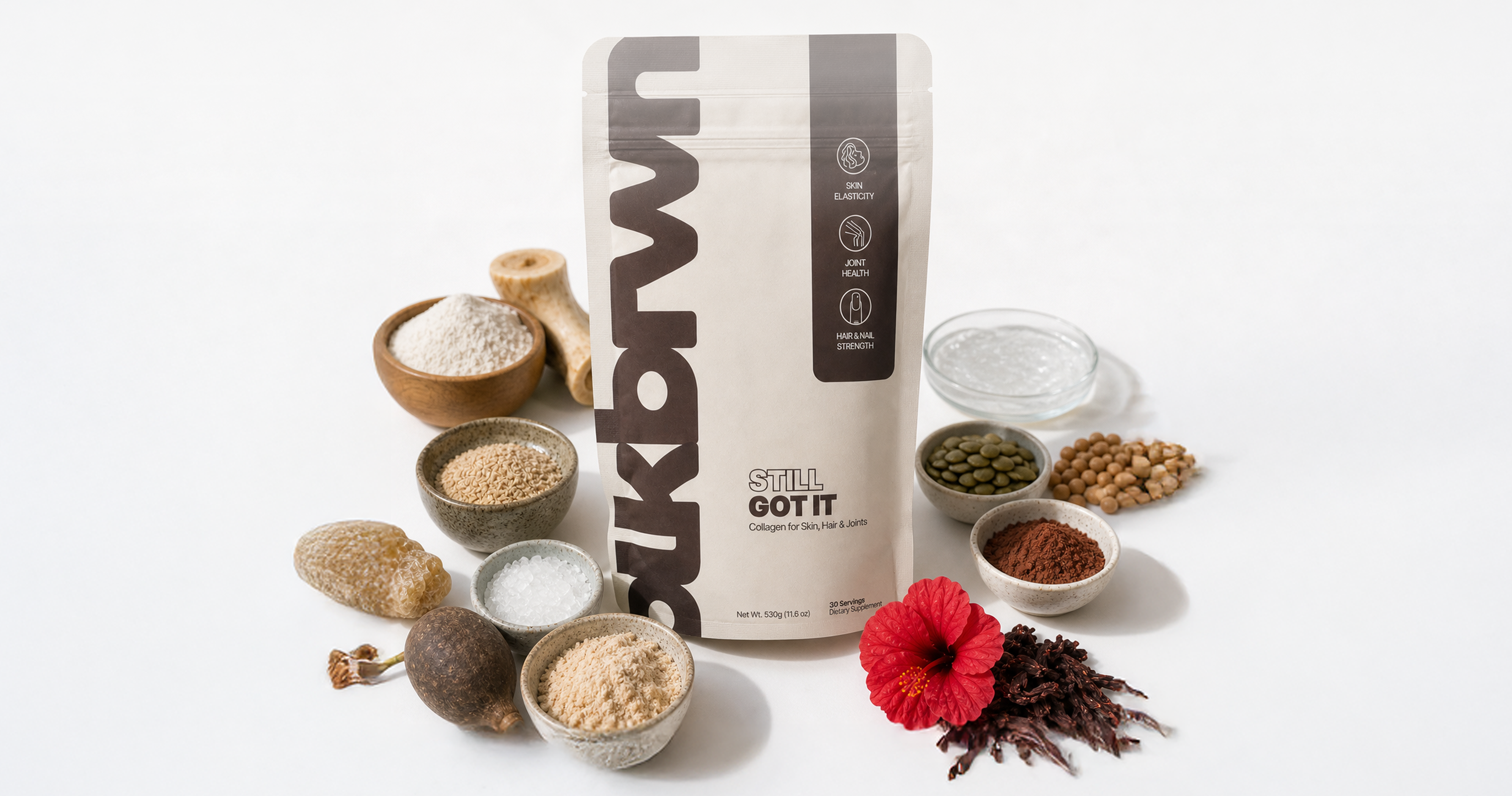A pouch of Still Got It collagen powder surrounded by its ingredients in small bowls on a white background.
