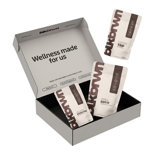 An open grey blkbrwn wellness box with three different supplement pouches floating in and around it.