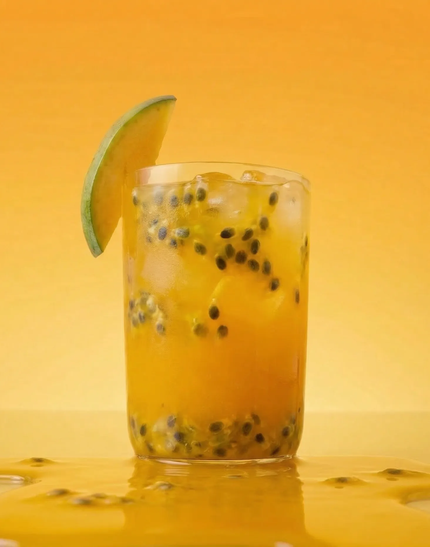 A refreshing glass of passion fruit juice with seeds and ice cubes, garnished with a slice of green fruit. The background is a bright orange gradient.