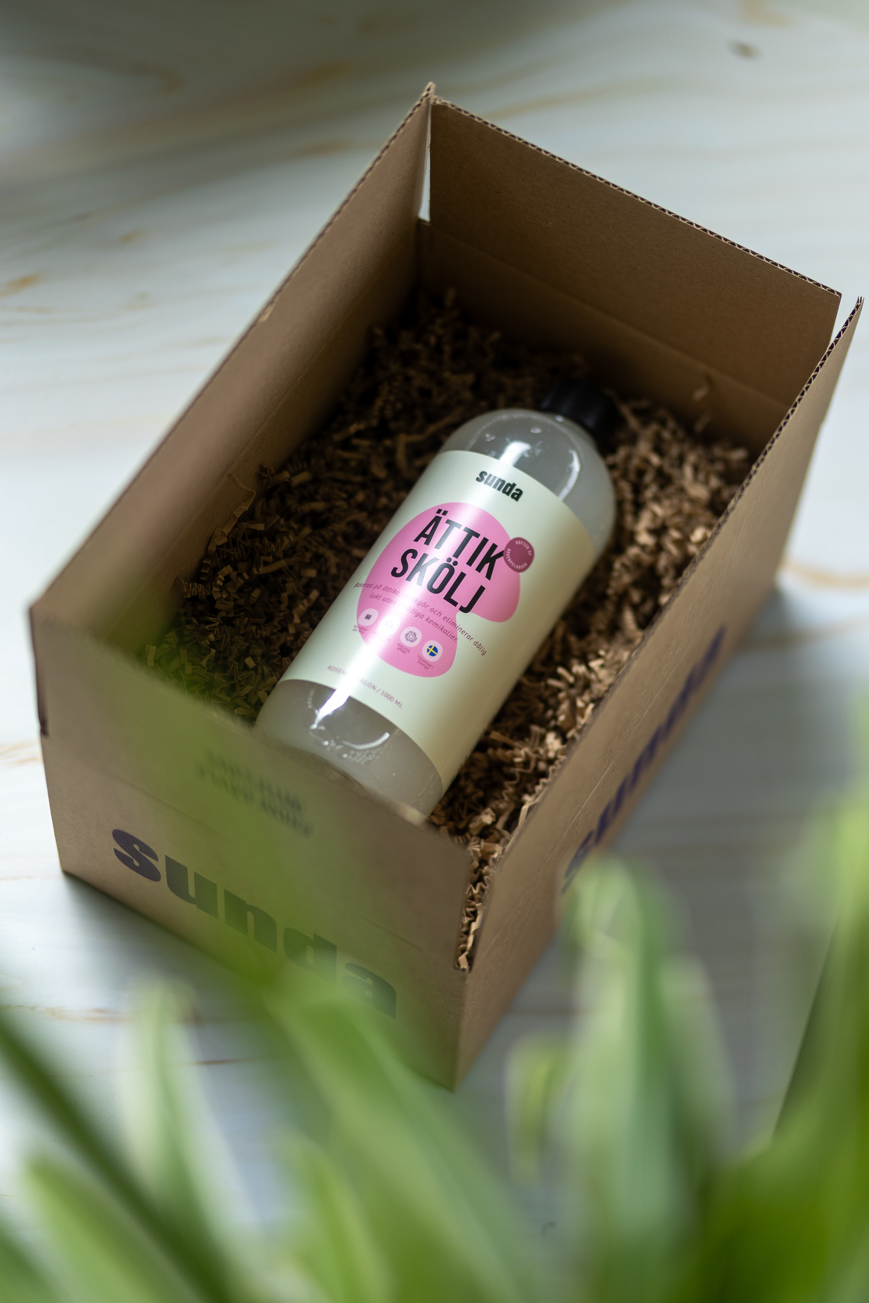 A bottle labeled 'Ättik Skölj' in a cardboard box with packing material.