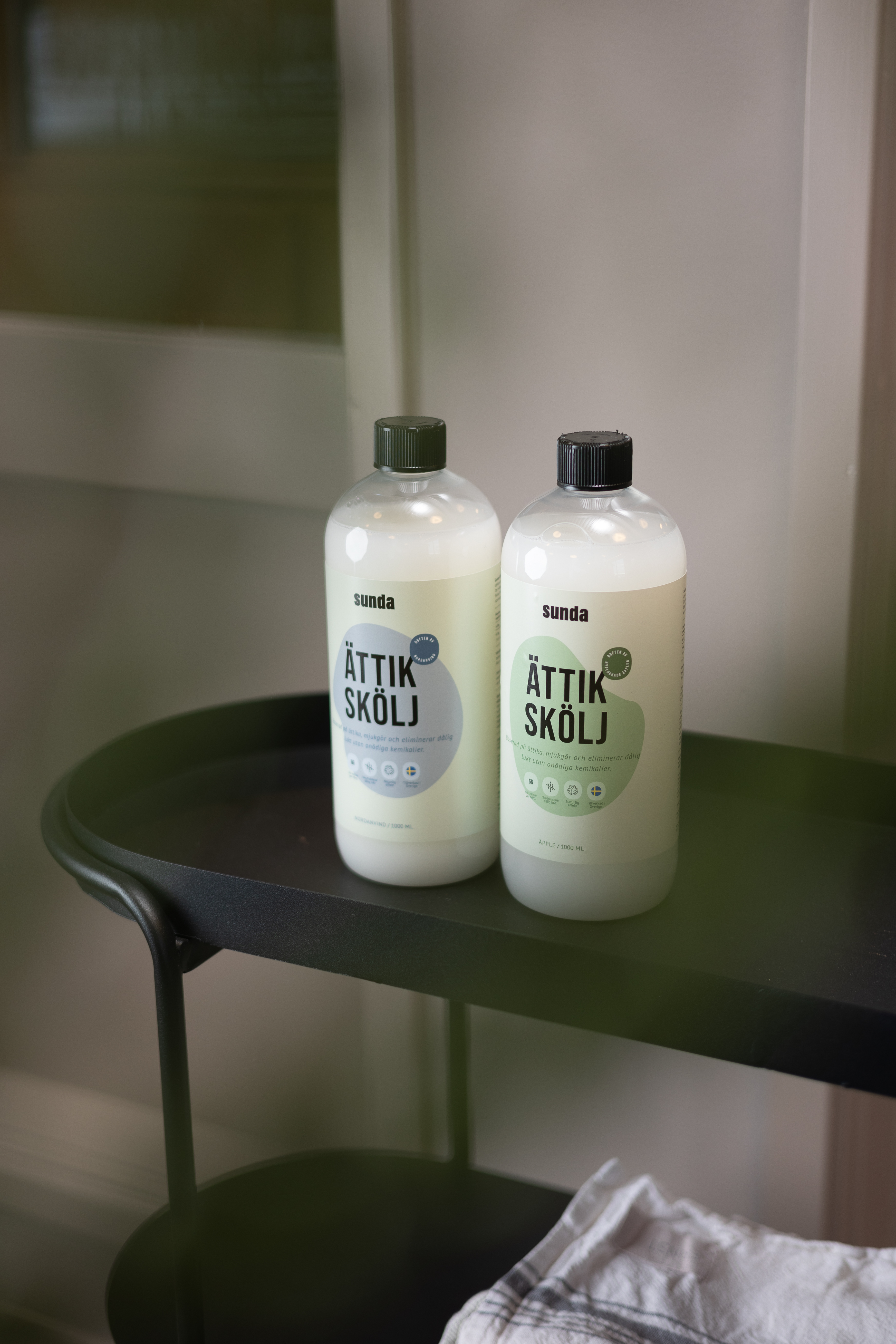 Two bottles of cleaning product on a black cart.