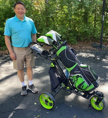 Man standing next to a golf cart with green and black golf bags.