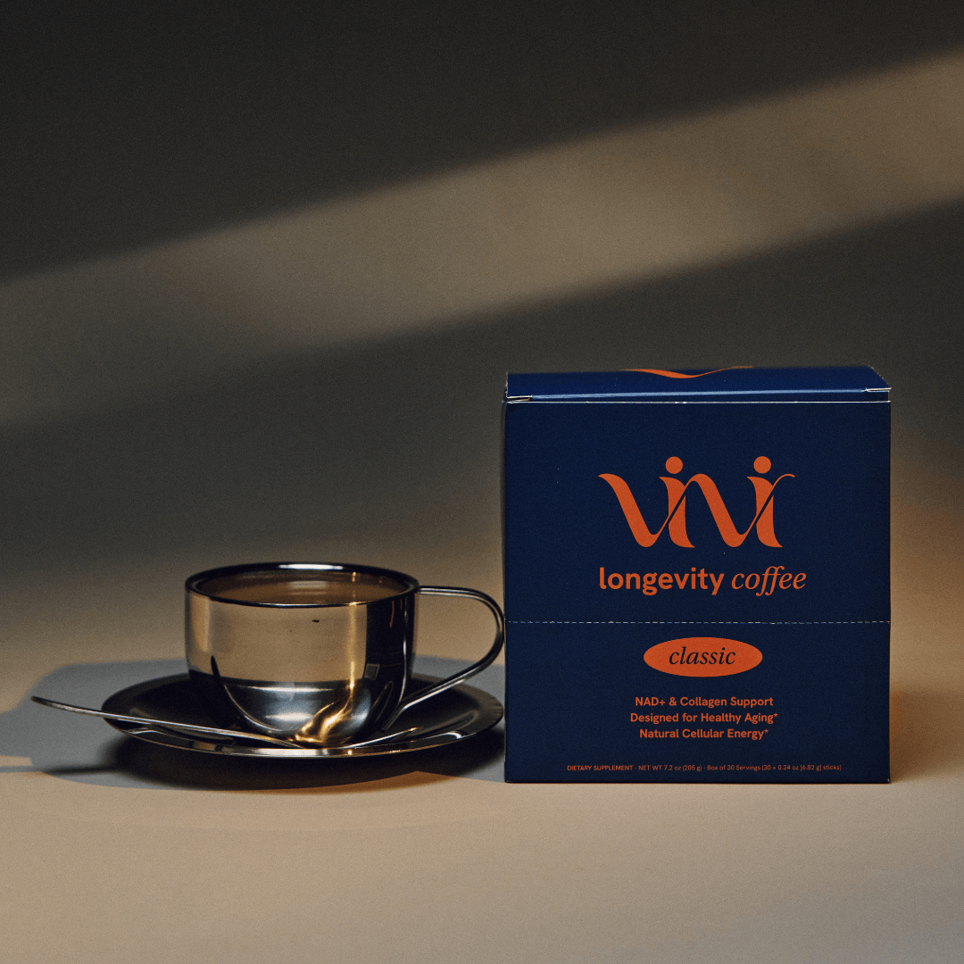 A blue box of Vivi Longevity Coffee next to a filled stainless steel coffee cup and saucer.
