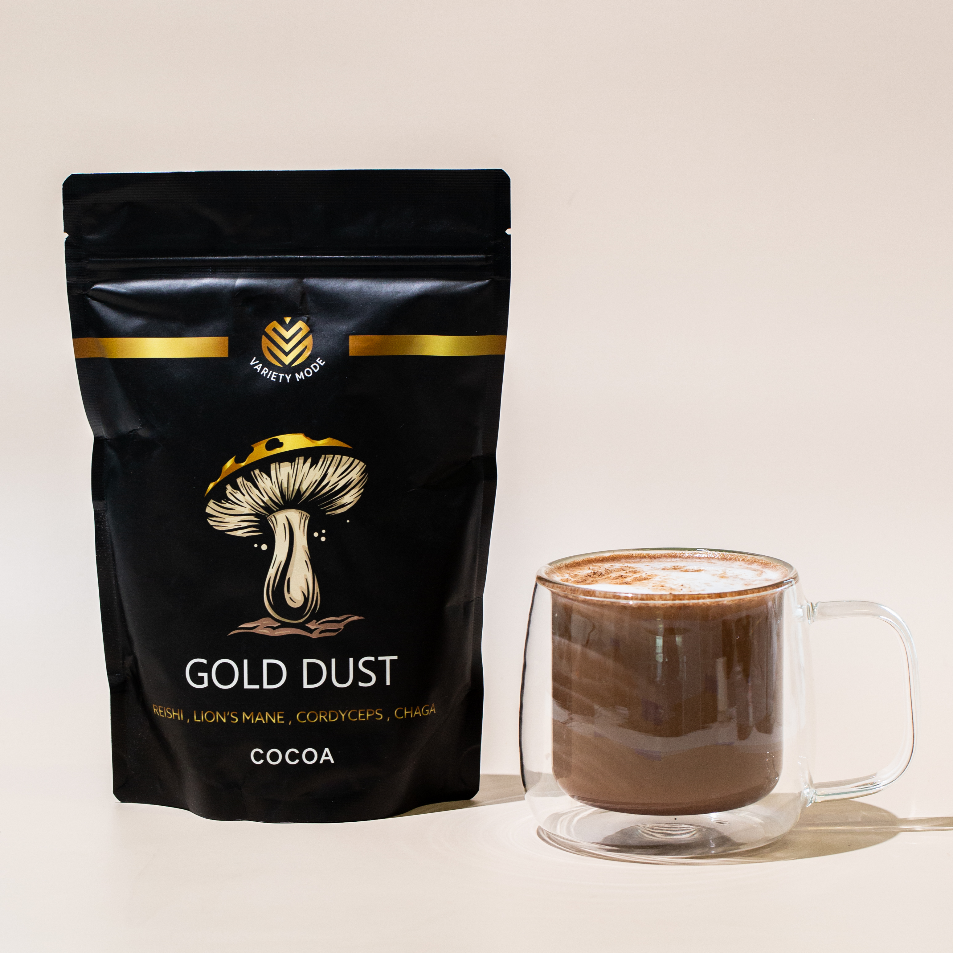 Black bag labeled 'Gold Dust' next to a glass mug of cocoa.