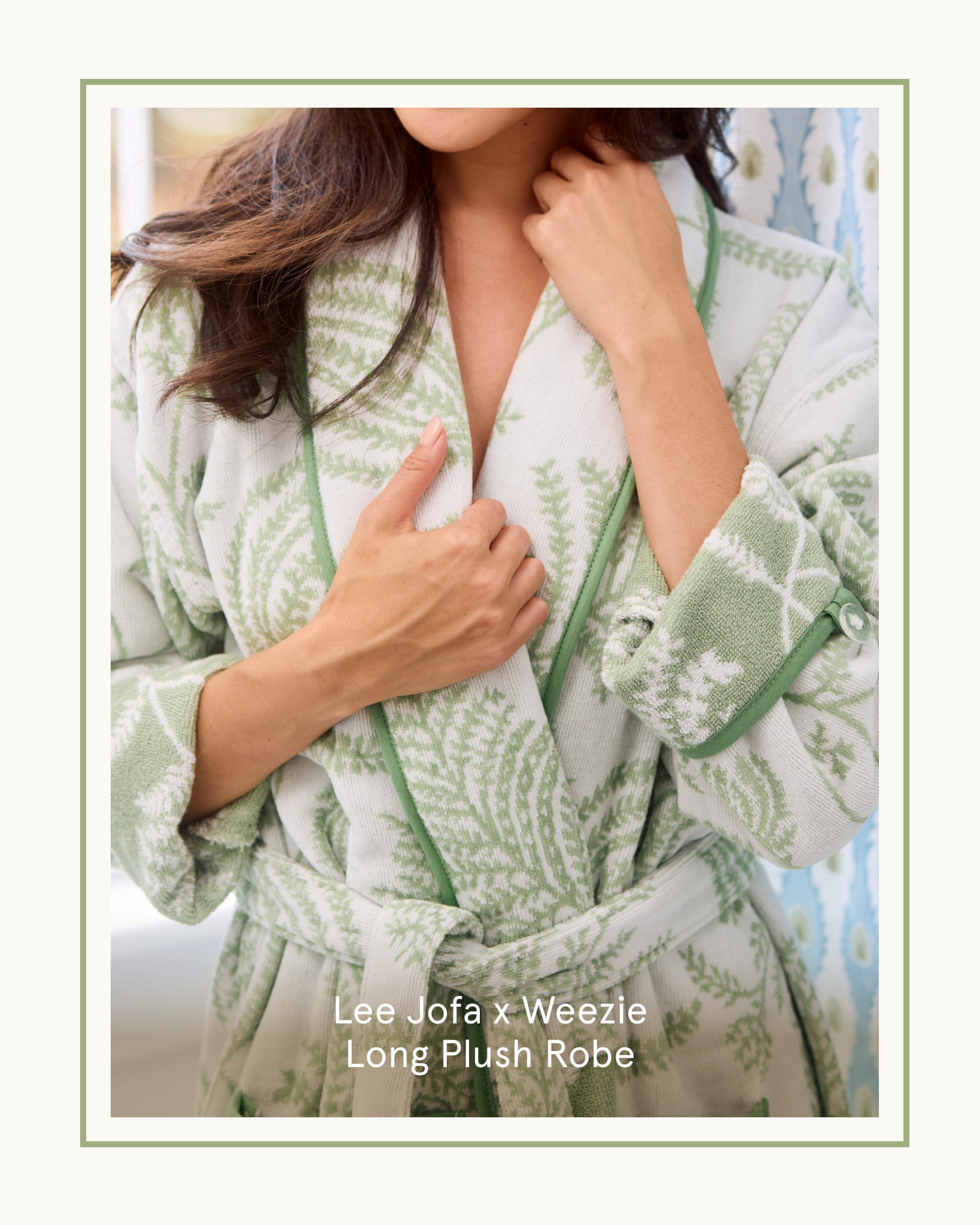 A woman with long brown hair wearing a white and green patterned plush robe.
