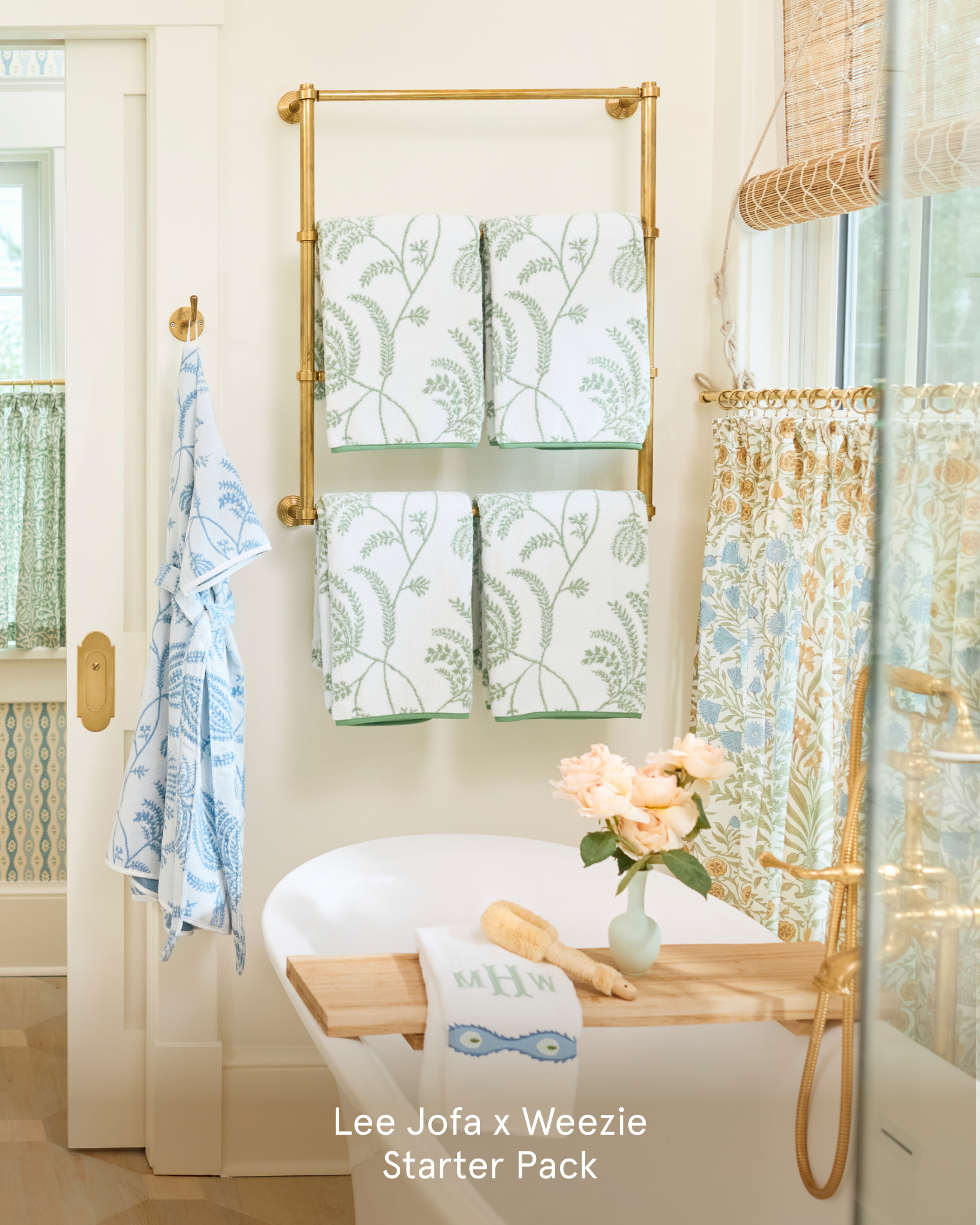 Patterned towels and a robe on display in a bathroom with a white freestanding tub.