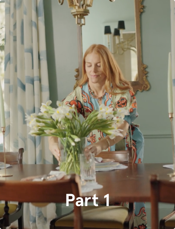 A woman with red hair placing flowers on the table.