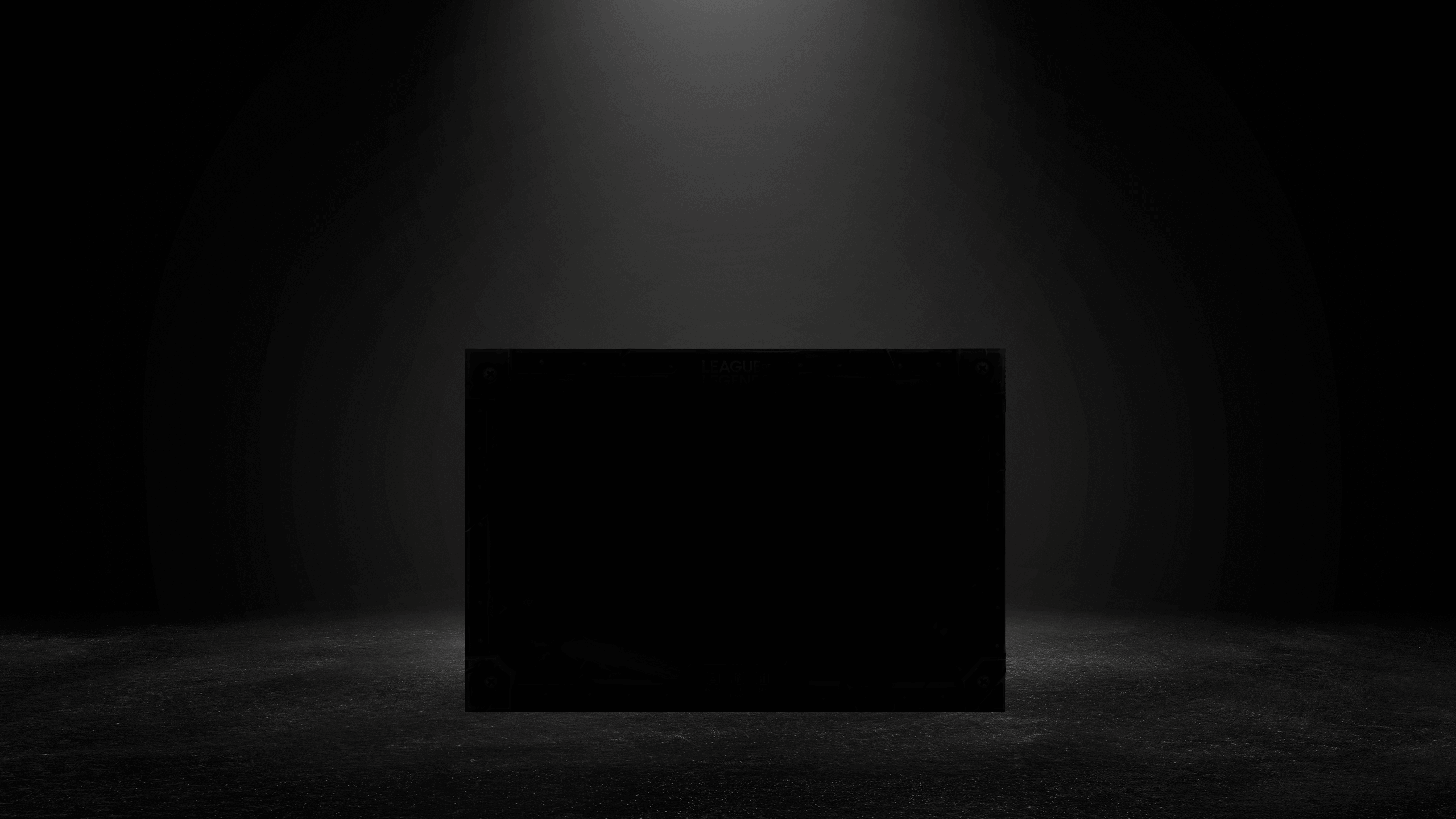 A black box stands on a dark floor, illuminated by a single spotlight from above in a dark room.